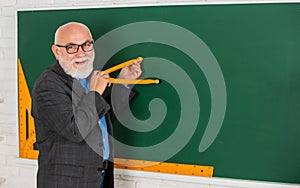 Senior man teacher use compass tool. bearded tutor man draw with compass on blackboard. back to school. Math graphic