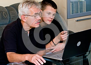 Senior man and teenager on laptop