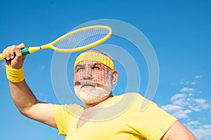 Senior man tennis player serving. Freedom retirement concept. Senior male is enjoying sporty lifestyle.