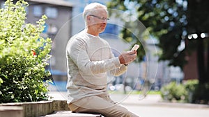 Senior man texting message on smartphone in city