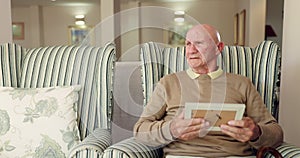 Senior, man and thinking with photo for grief depression in home or broken heart mourning, thoughts or memories. Elderly