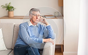 Senior Man Thinking About Retirement Sitting On Couch At Home