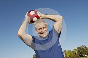 Senior Man Throwing Soccer Ball