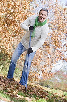 Senior man tidying leaves in garden photo