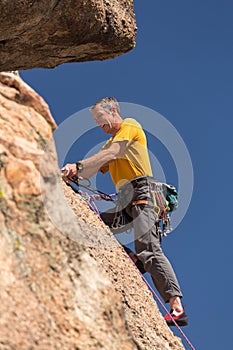 Senior man at top of rock climb in Colorado