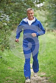 Senior Man In Tracksuit Running Through Countryside