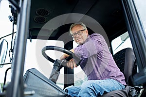 Senior man in tractor at farm