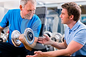 Senior man and trainer at exercise in gym
