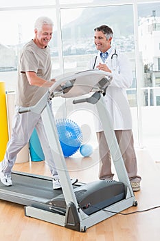 Senior man on treadmill with therapist