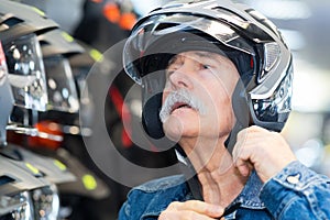 senior man trying on crash helmet