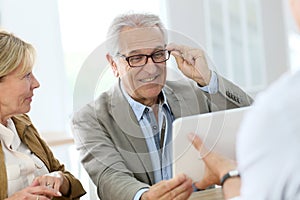 Senior man trying on eyeglasses in optical store