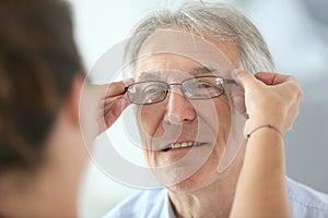 Senior man trying on new eyeglasses
