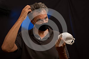 Man trying to decided what protective mask to wear photo