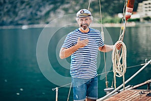 Senior man tying knot and securing a mooring for his hobby yacht sail boat