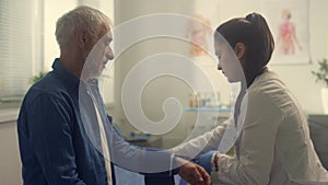 Senior man undergoing medical examination in clinic. Doctor measuring pressure.