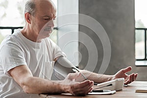 Senior man using a home blood pressure machine to check his vital statistics