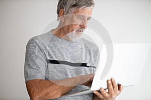 Senior man using a laptop computer at home