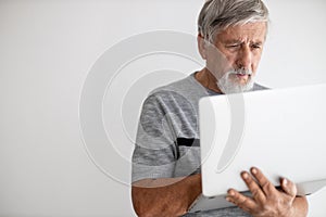 Senior man using a laptop computer at home