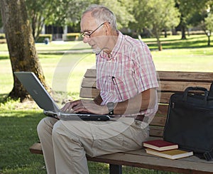 Senior man using laptop computer outdoors