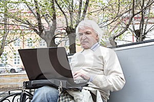 Senior man using laptop computer outdoors