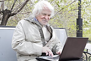 Senior man using laptop computer outdoors