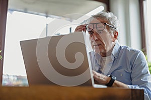 Senior man using laptop at home