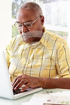 Senior Man Using Laptop At Home