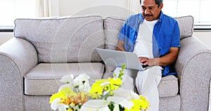 Senior man using laptop in living room 4k
