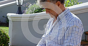 Senior man using laptop on porch steps 4k