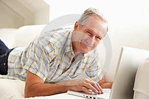 Senior Man Using Laptop Relaxing Sitting On Sofa