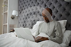 Senior man using laptop while sitting on bed