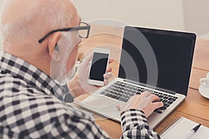 Senior man using laptop and smartphone mockup