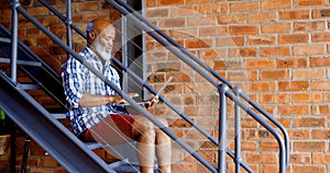 Senior man using laptop on stairs in living room 4k