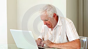 Senior man using laptop at the table