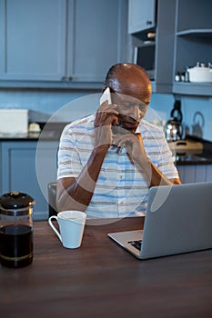 Senior man using laptop at table