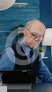 Senior man using laptop and tablet in same time