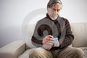 Senior man using medical device to measure blood pressure