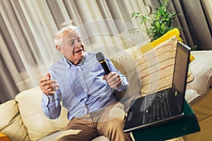 Senior man using microphone and singing karaoke