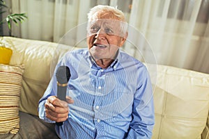 Senior man using microphone and singing karaoke