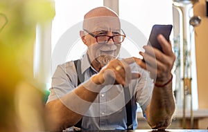 Senior man using a mobile phone at home