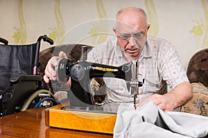 Senior Man Using Old Fashioned Sewing Machine