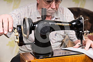 Senior Man Using Old Fashioned Sewing Machine