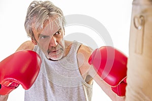 Senior man using a punching bag