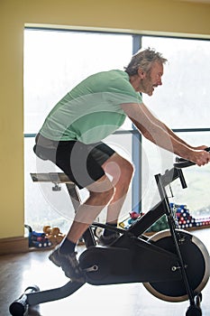 Senior man using a spinning bike