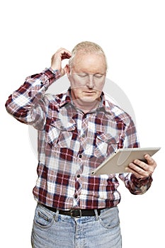 Senior man using tablet computer looking confused