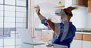 Senior man using virtual reality headset in kitchen 4k