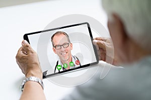 Senior Man In Videochat Or Videoconference With Doctor photo
