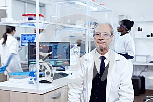 Senior man with virus on computer display looking at camera