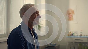 Senior man visiting cardiologist in clinic close up. Woman doctor checking pulse