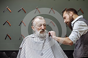 Senior man visiting hairstylist in barber shop.